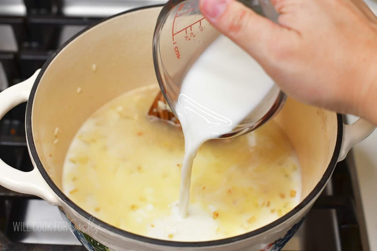 adding milk to the pot with rice.