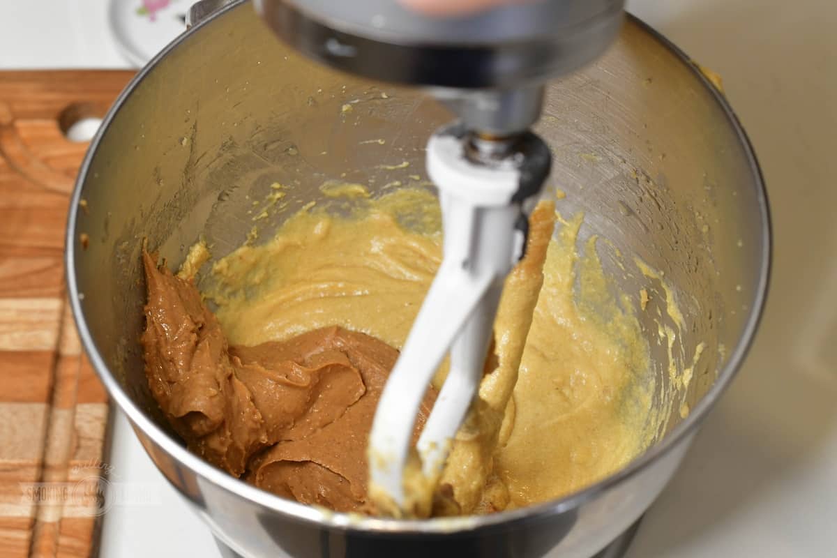 adding peanut butter to the creamed butter in a mixer.