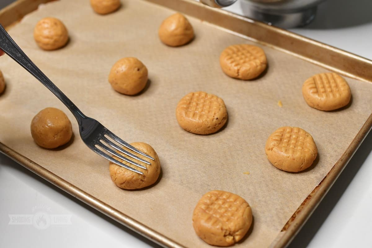 pressing on the cookie dough balls with a fork.