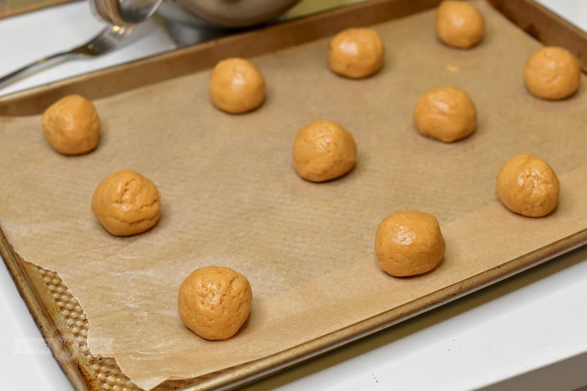 rolled cookie dough balls on the baking sheet.