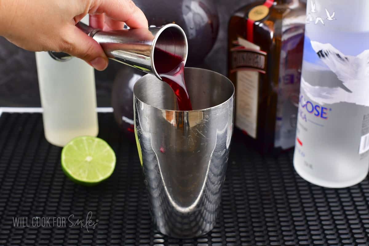 pouring pomegranate juice into the cocktail shaker.