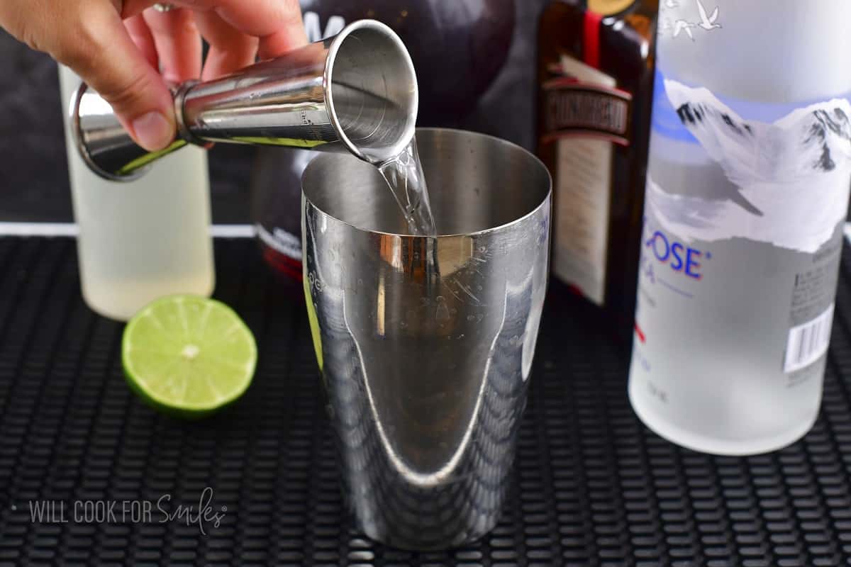 pouring vodka into the cocktail shaker.