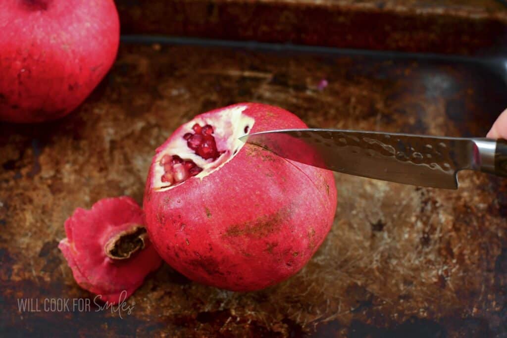cutting down the side of a pomegranate.