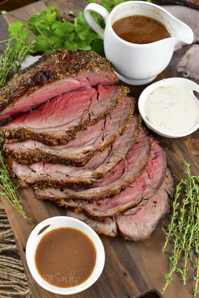 top view of sliced prime rib with au jus and horsey sauce.