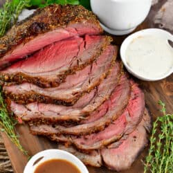 closeup of sliced prime rib with sauces around.