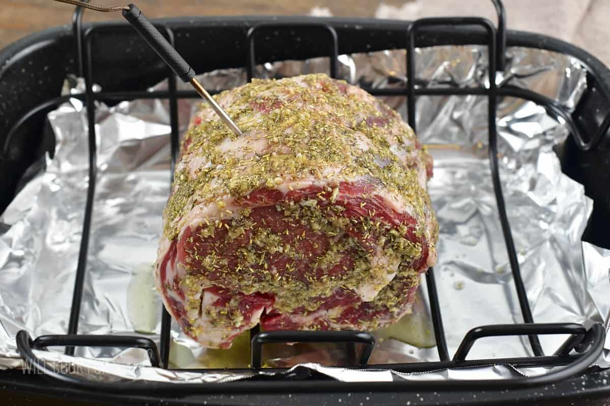 prime rib with seasoning and thermometer inserted.