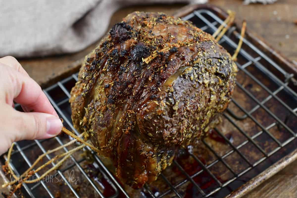 taking off the cooking twine off the roast.