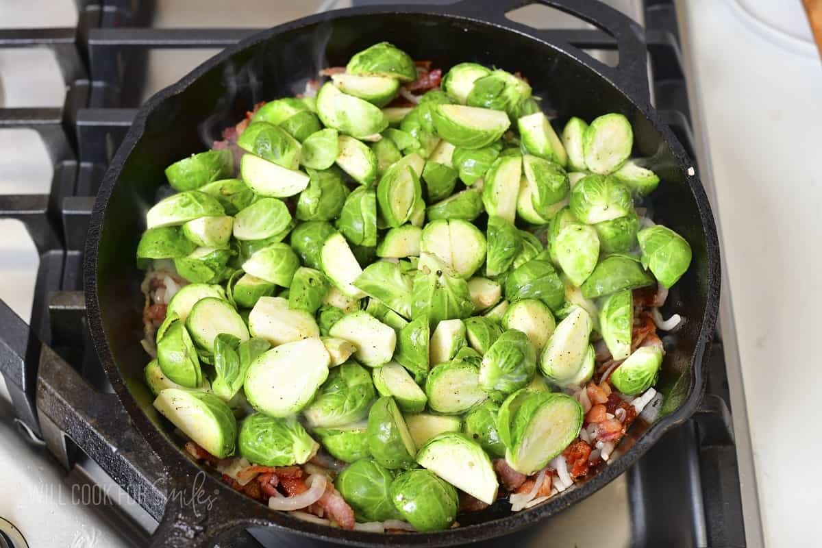 adding cut brussels to the skillet with onions and bacon.