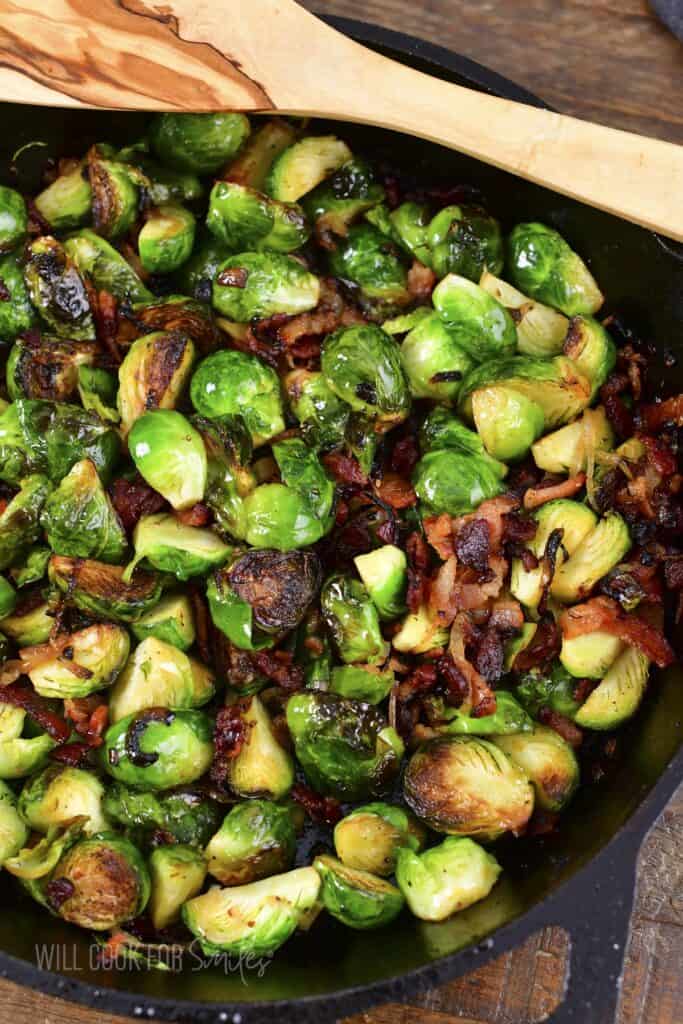 closeup of roasted brussels sprouts in a skillet with a spoon.