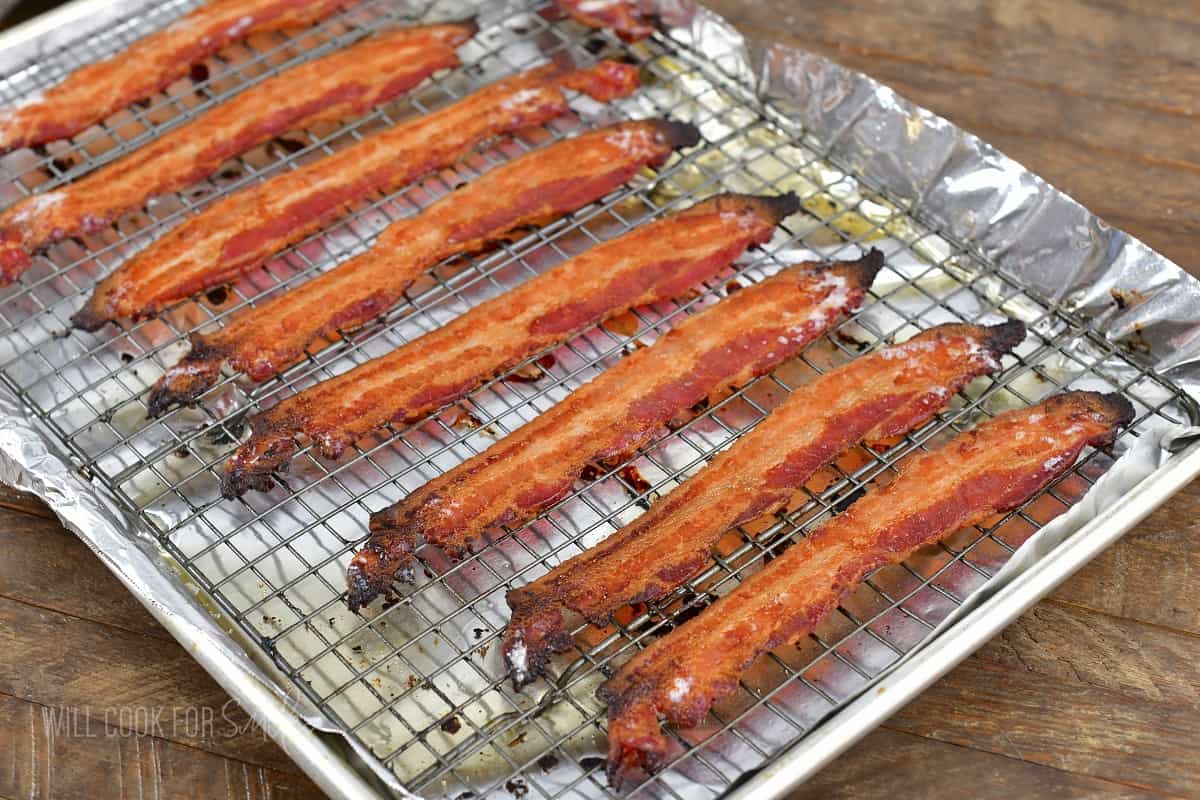 cooked bacon on a wire rack inside a rimmed tray.