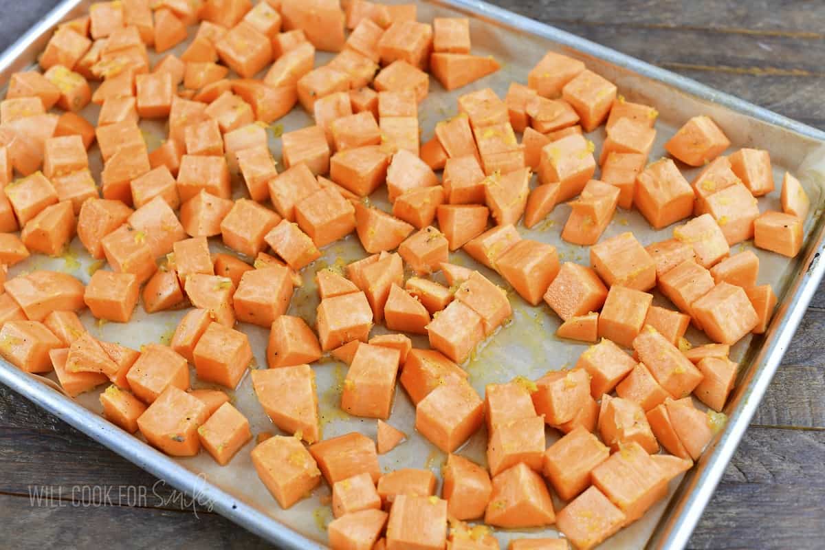 seasoned sweet potatoes on a baking tray.