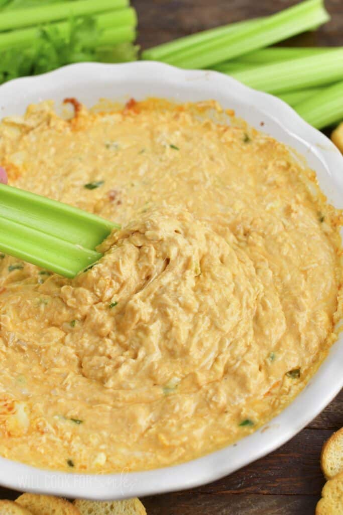 scooping out some buffalo chicken dip with celery.
