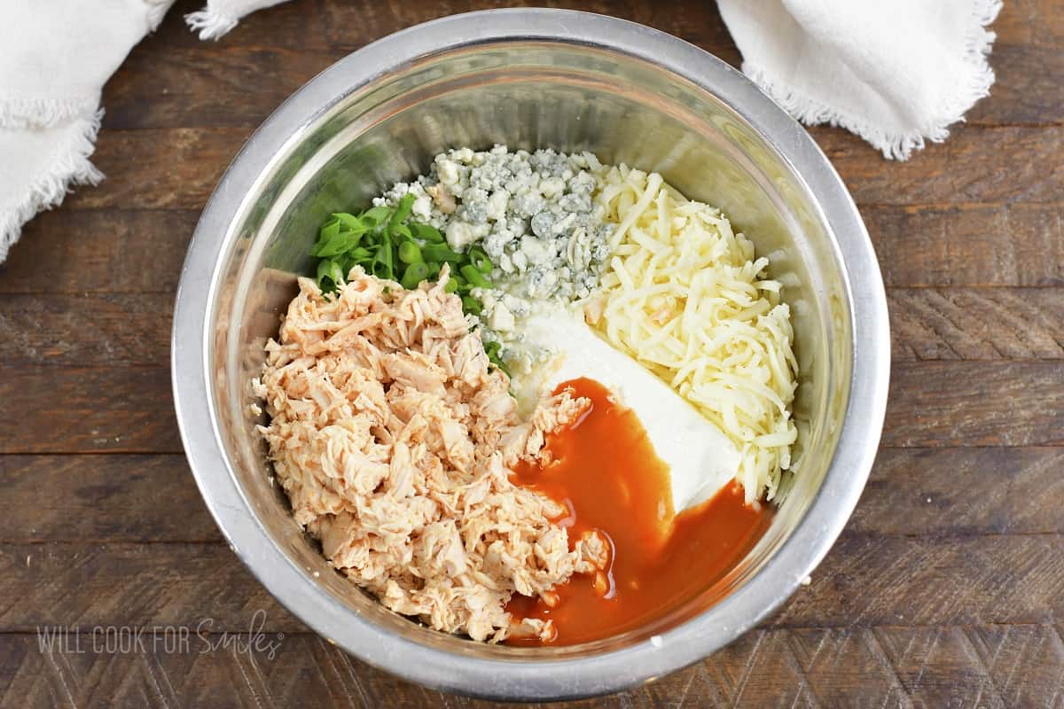 ingredients for buffalo chicken dip in a mixing bowl.