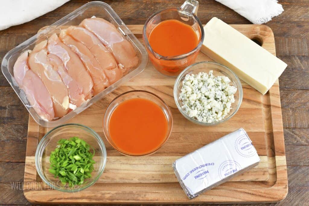 ingredients for buffalo chicken dip on cutting board.