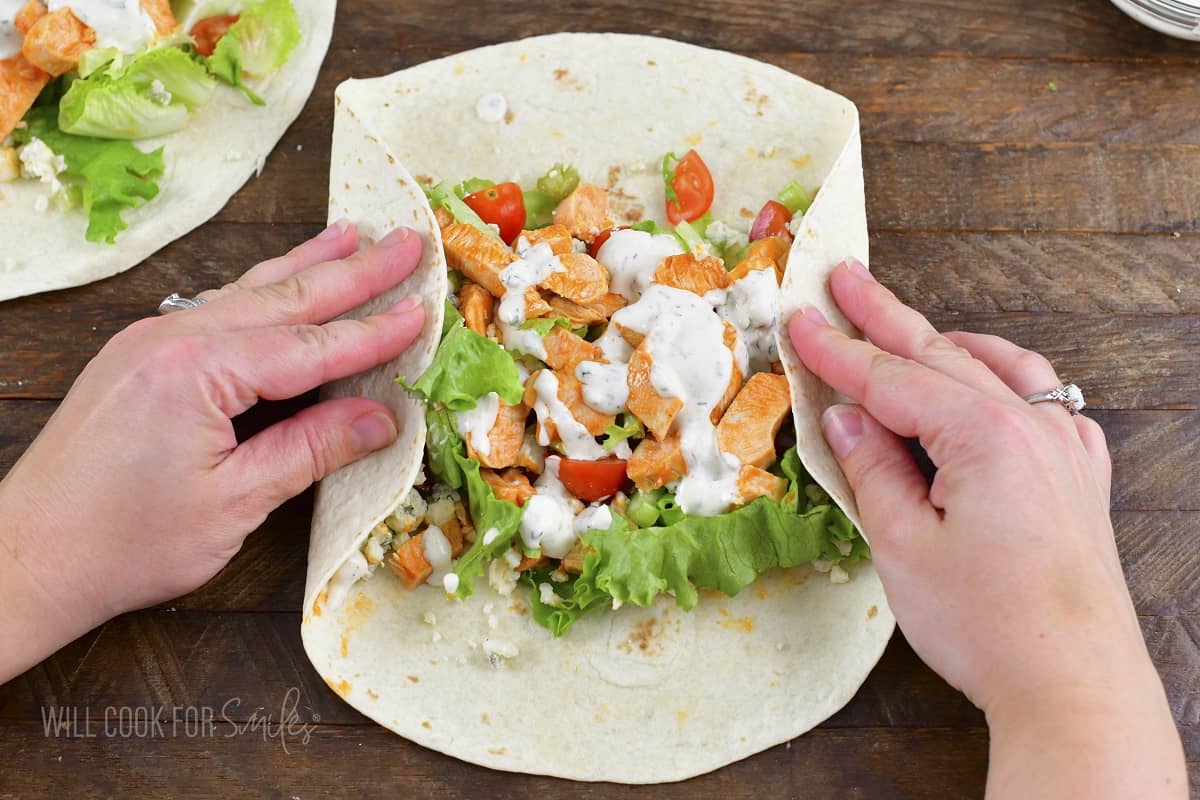 folding the sides of the tortilla around the filling.