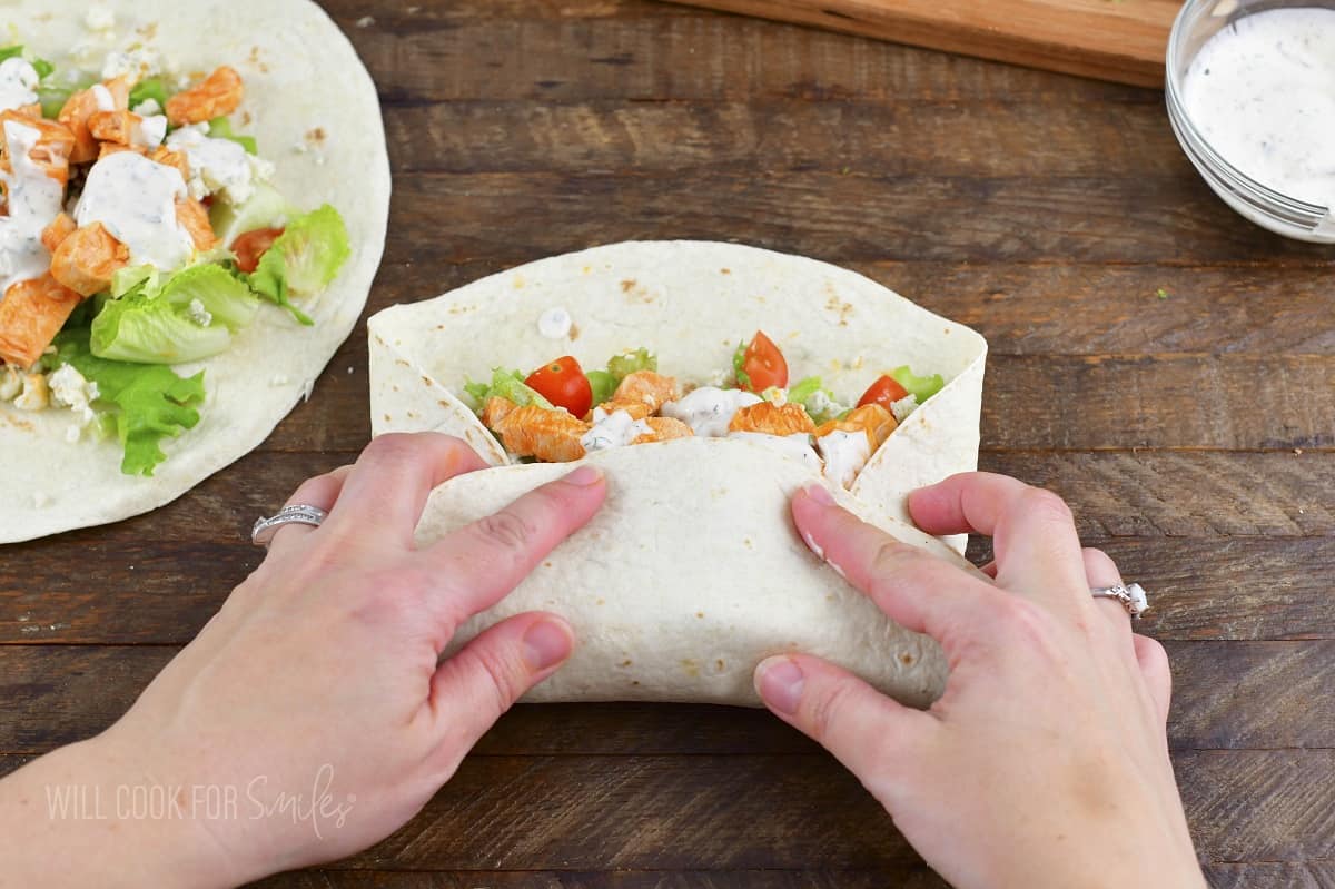 rolling up buffalo chicken wrap.