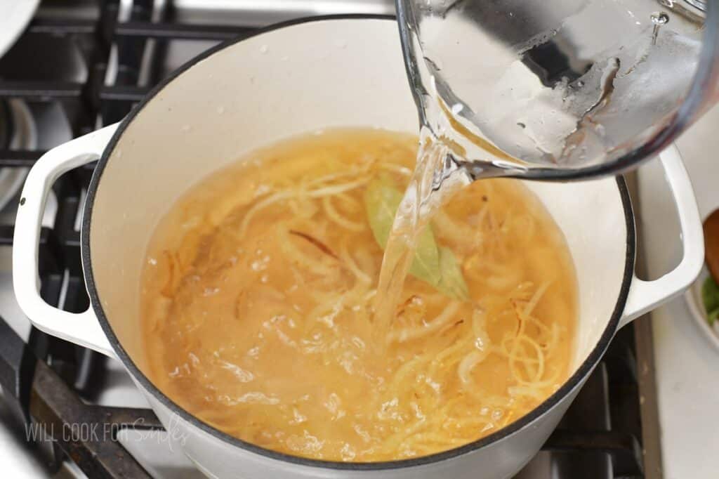 adding water to to the pot for soup.