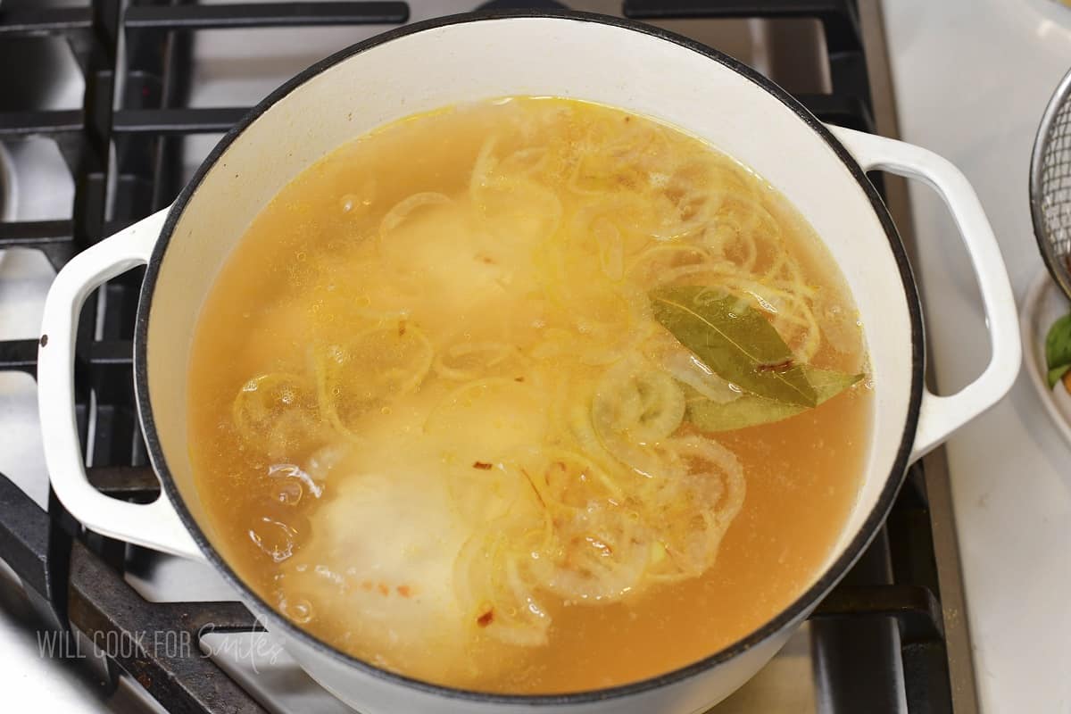 cooking chicken breasts in a pot in a broth.