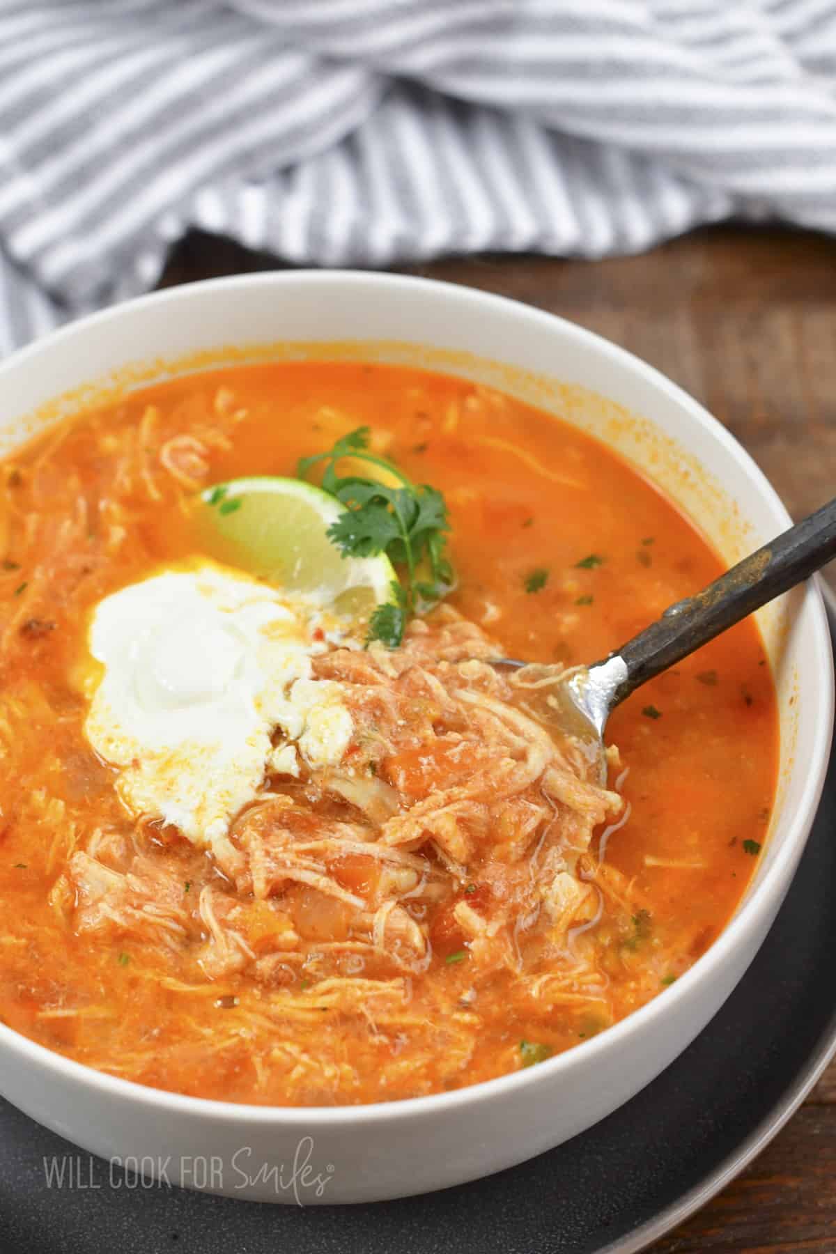 spooning out some enchilada soup from a bowl.