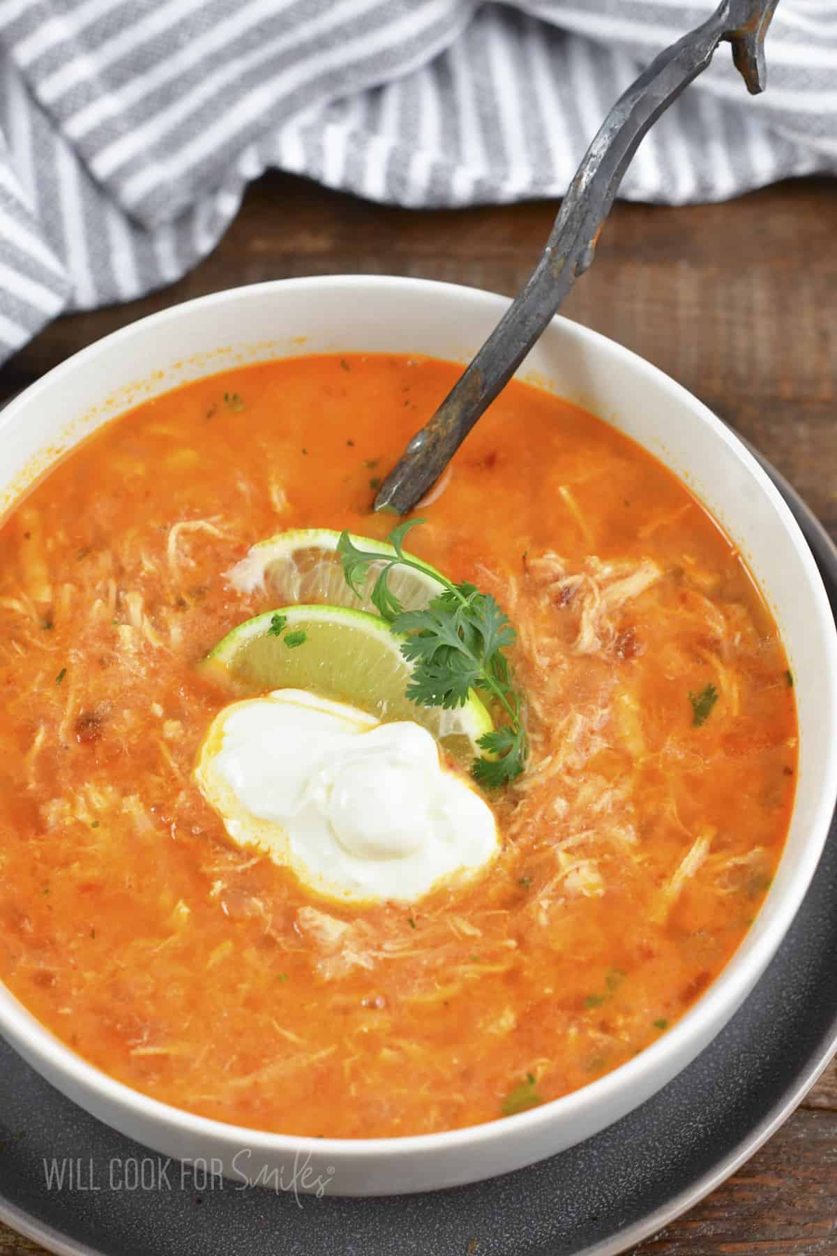 top view of enchilada soup in a bowl with toppings.