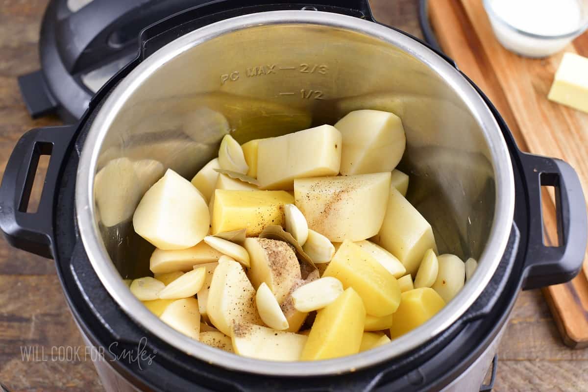 cubed potatoes with garlic and seasoning in instant pot.