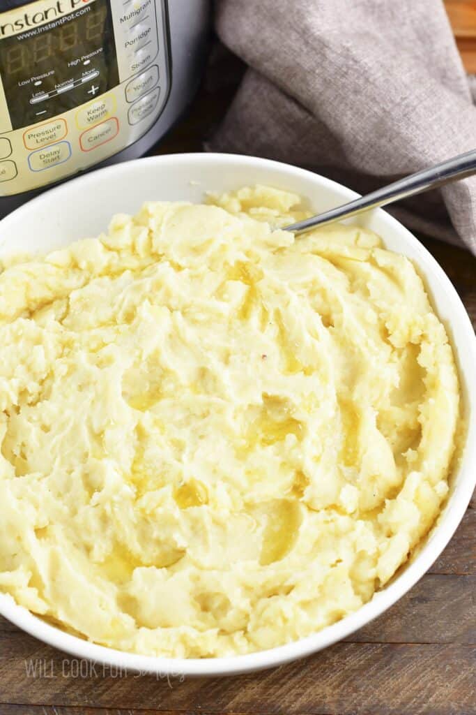 top view of mashed potatoes in a white bowl with a spoon.