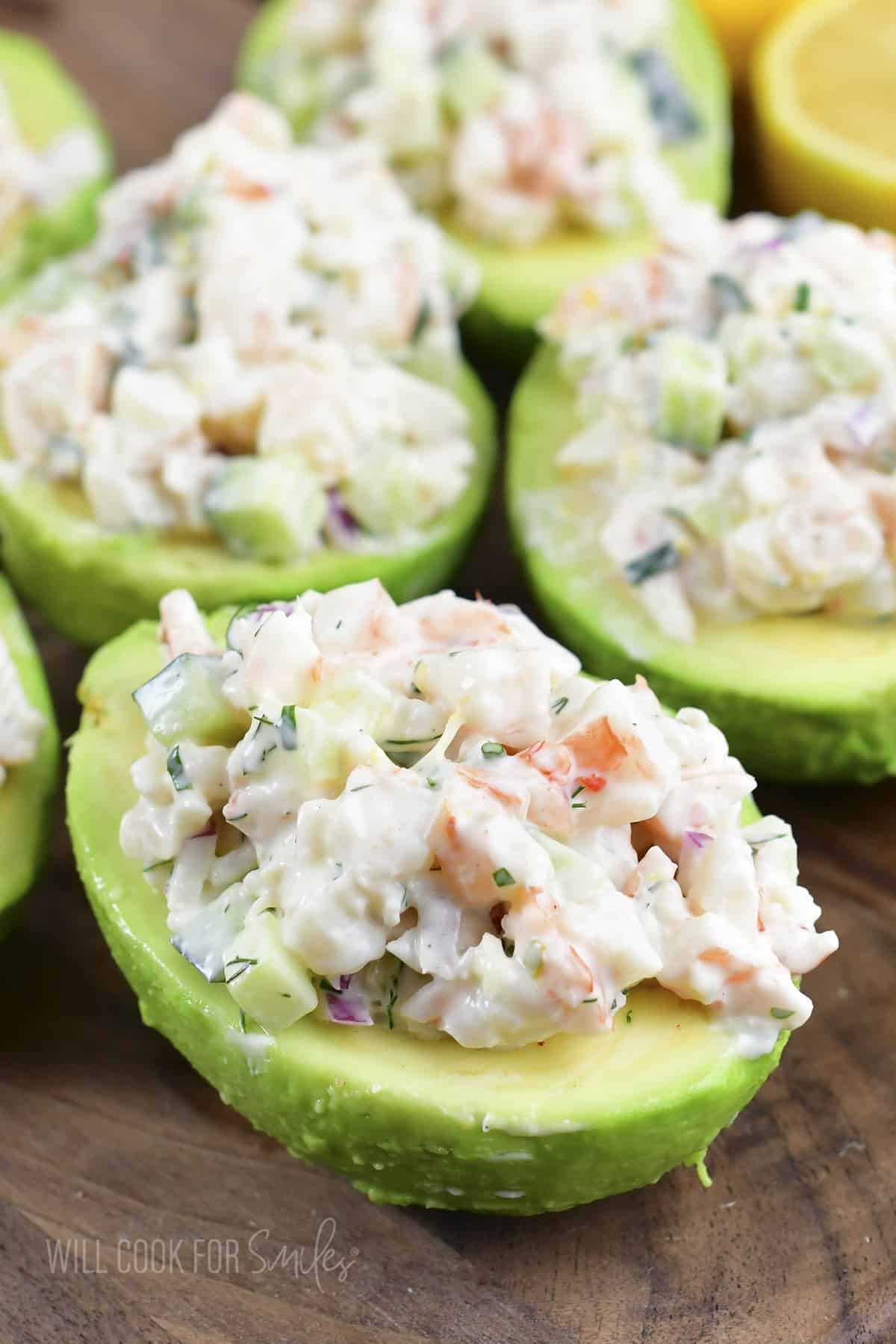 closeup of shrimp salad stuffed avocado halves on wood.