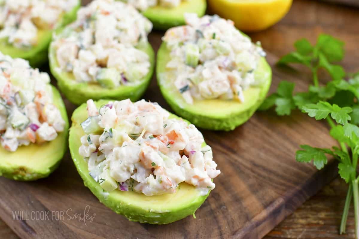 closeup of shrimp salad stuffed avocados and herbs.