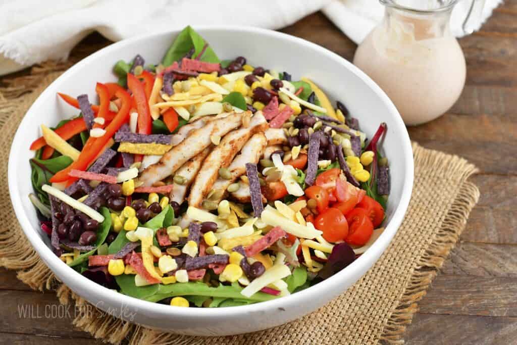 closeup of southwest salad in white bowl and creamy dressing.