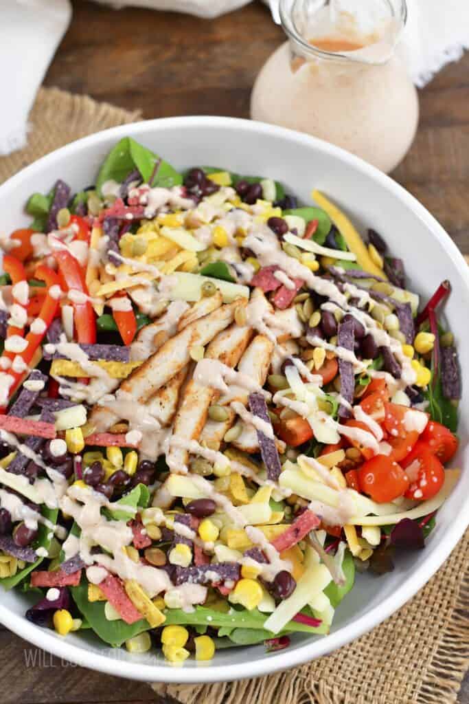 top view of southwest salad in a bowl drizzled with dressing.