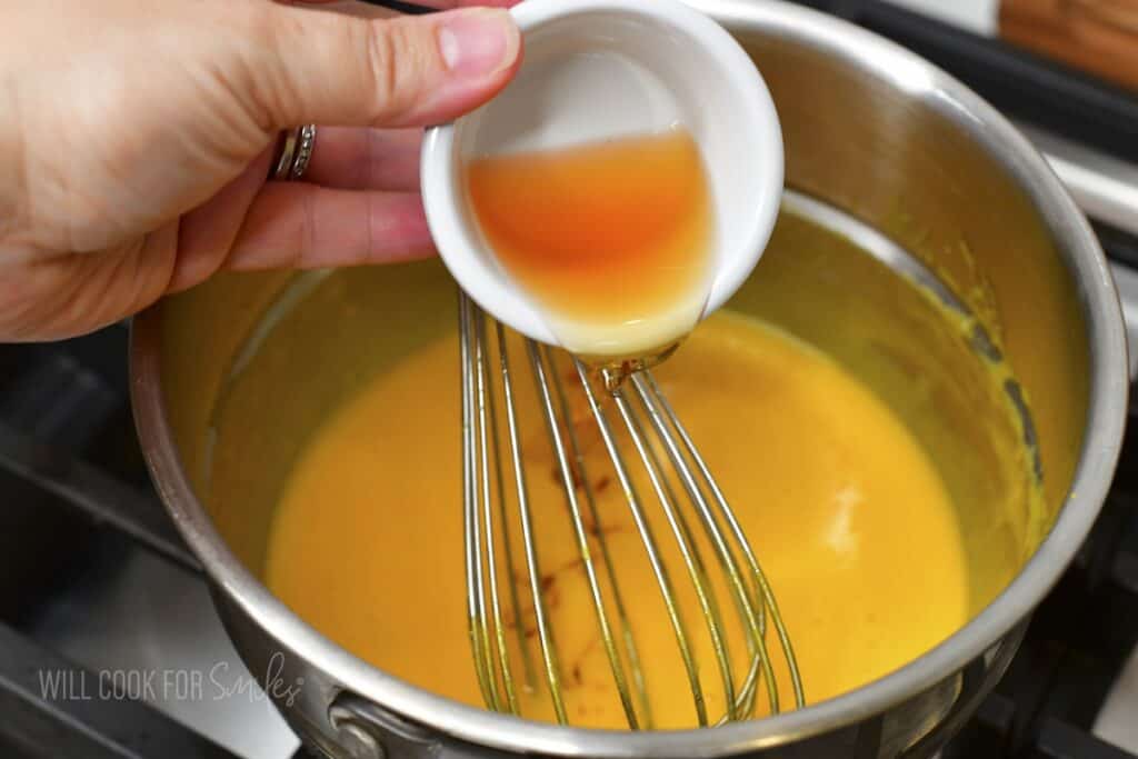 adding amaretto into the egg yolks in a double boiler.