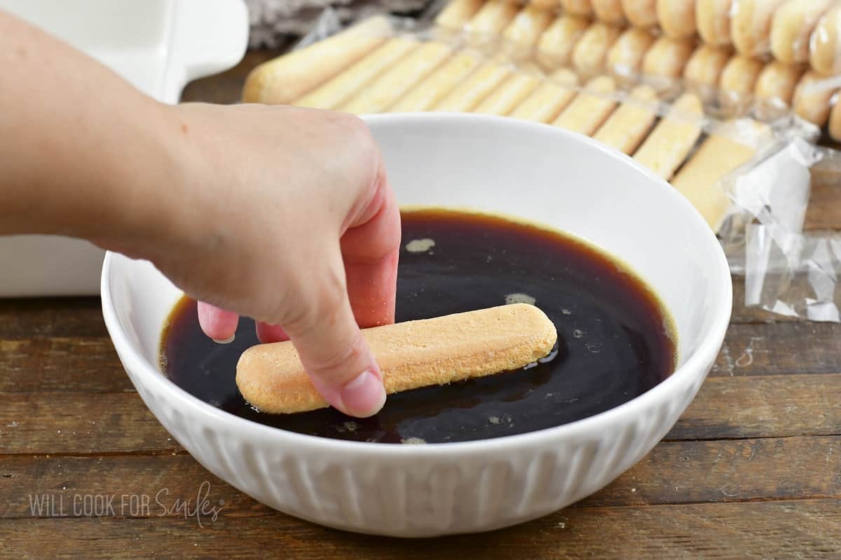 dipping a lady finger cookie into espresso.
