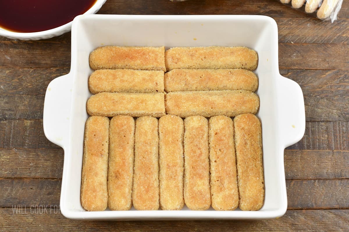 lady fingers dipped in espresso layered in a baking dish.