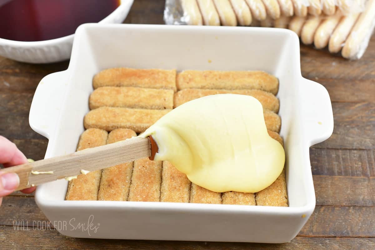 adding mascarpone cream over the layer of lady fingers.