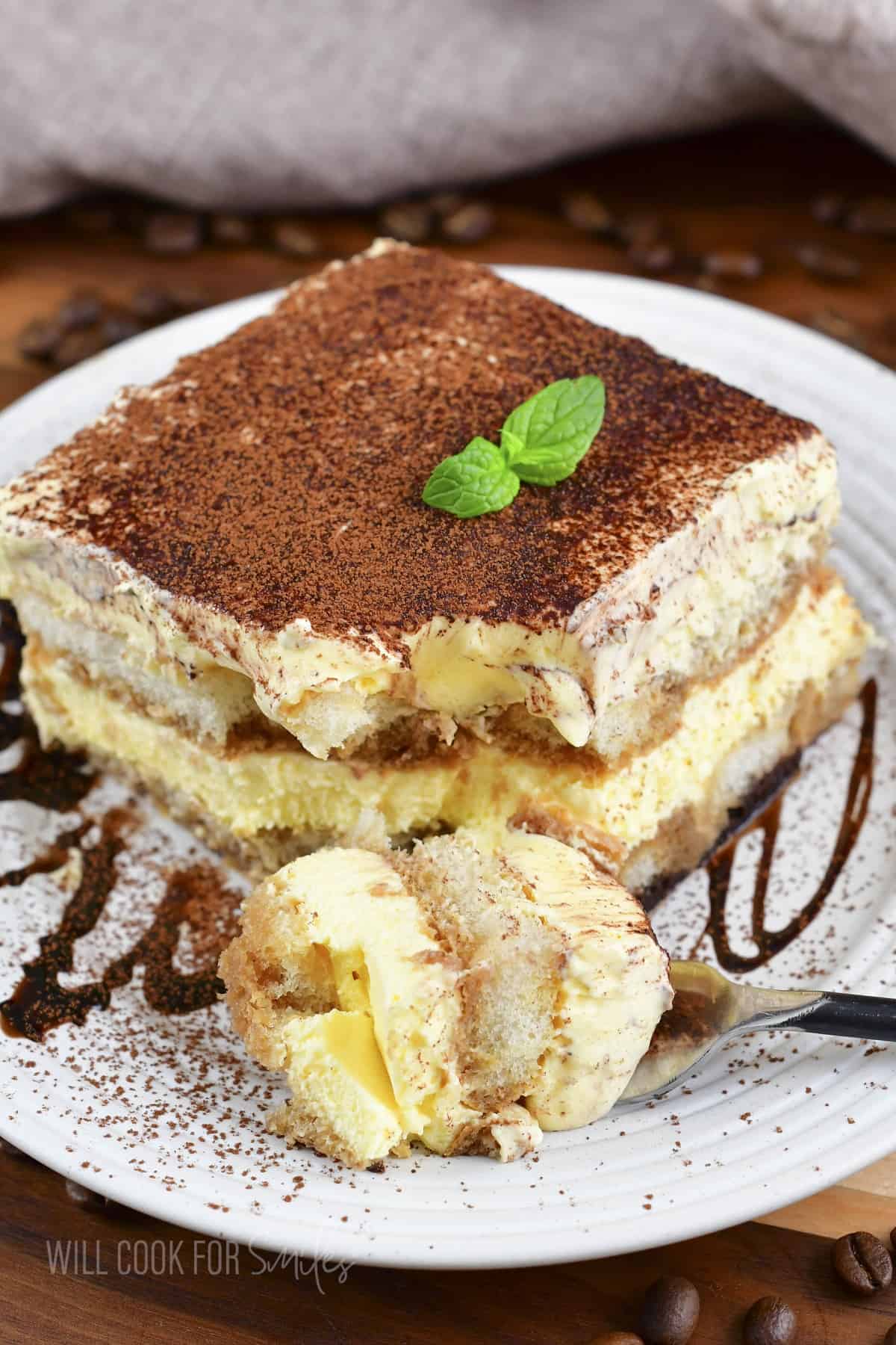 front closeup of a slice of tiramisu with a piece taken out.