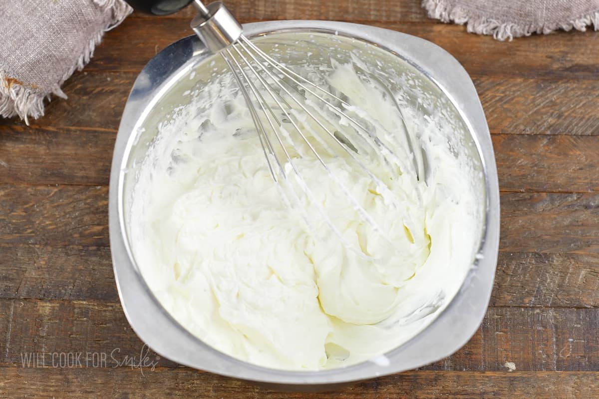 whipped cream in a small bowl with a whisk.