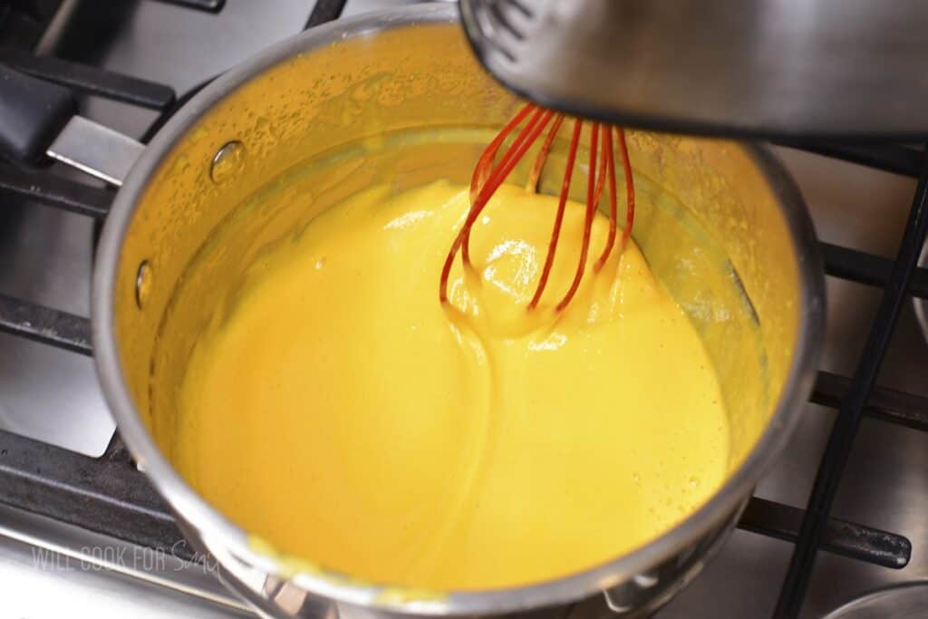 whisking egg whites and sugar in double boiler.