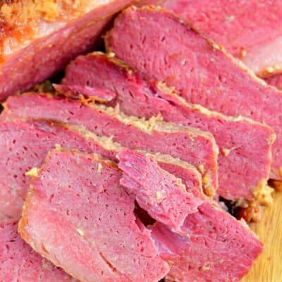pulled apart slice of corned beef next to other slices.