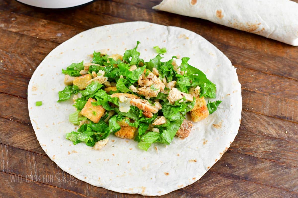 chicken Caesar salad spread on a large tortilla.