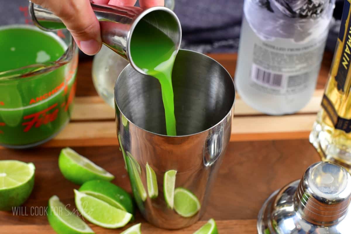 adding fresh cucumber juice to the cocktail shaker.