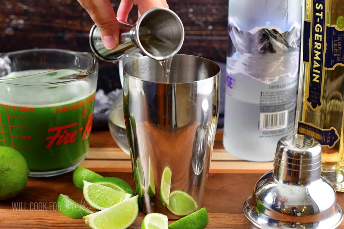 adding St. Germain liquor to the cocktail shaker.