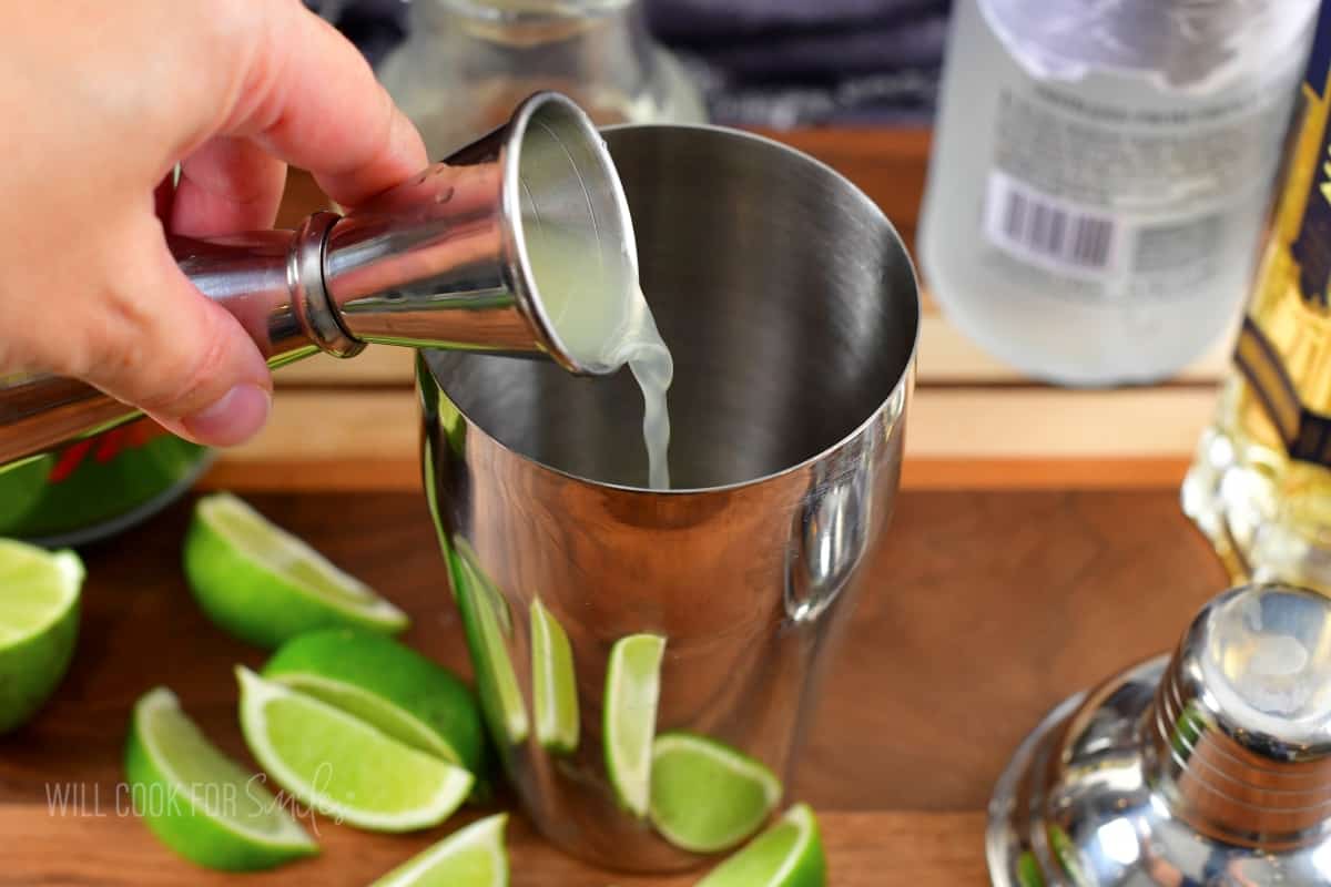 adding lime juice to the cocktail shaker.