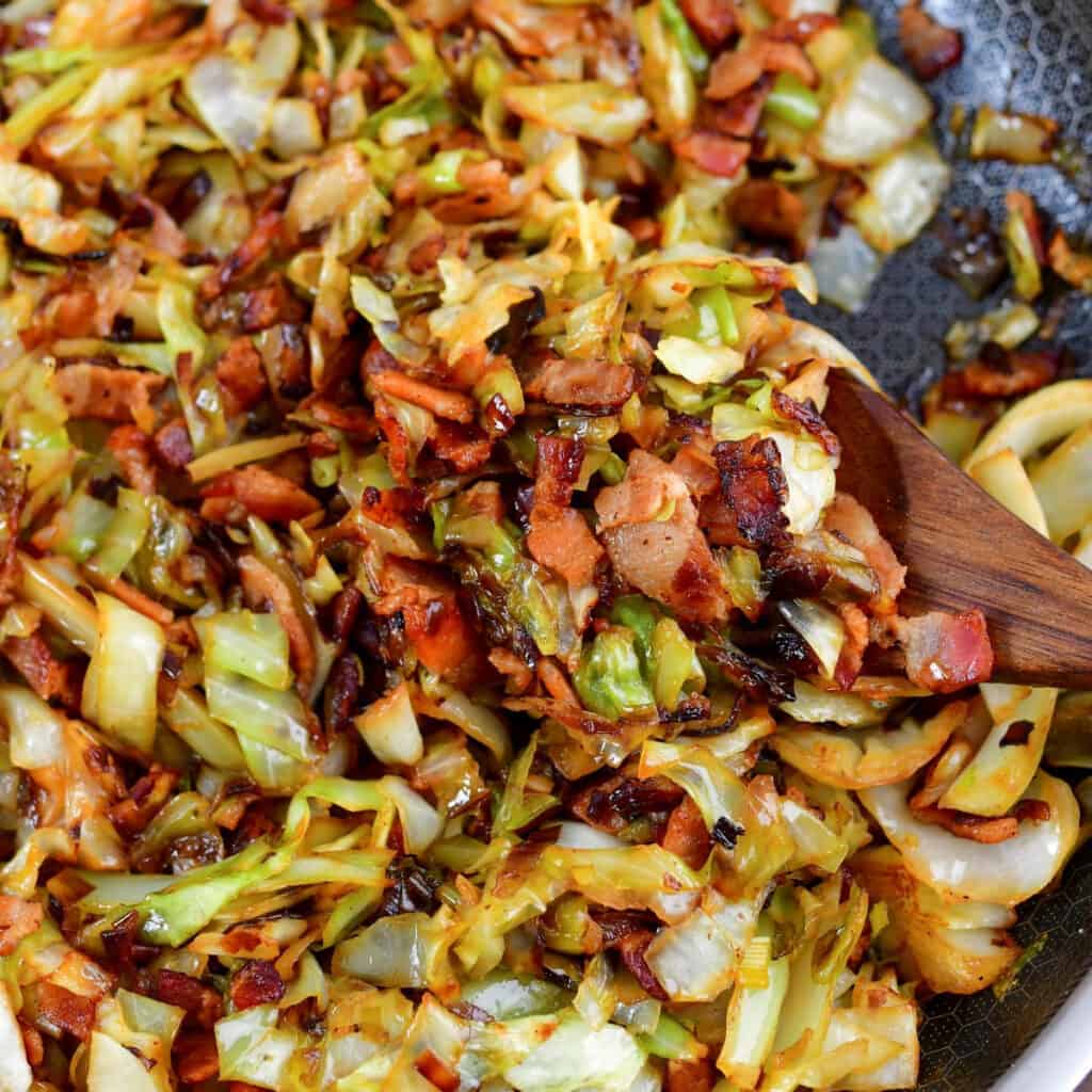 closeup of scooping of fried cabbage and bacon.