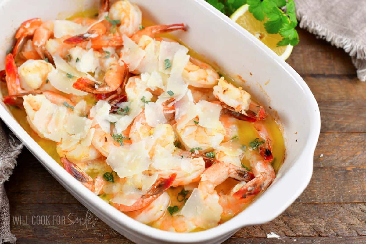 pink baked shrimp with parmesan cheese in white dish.