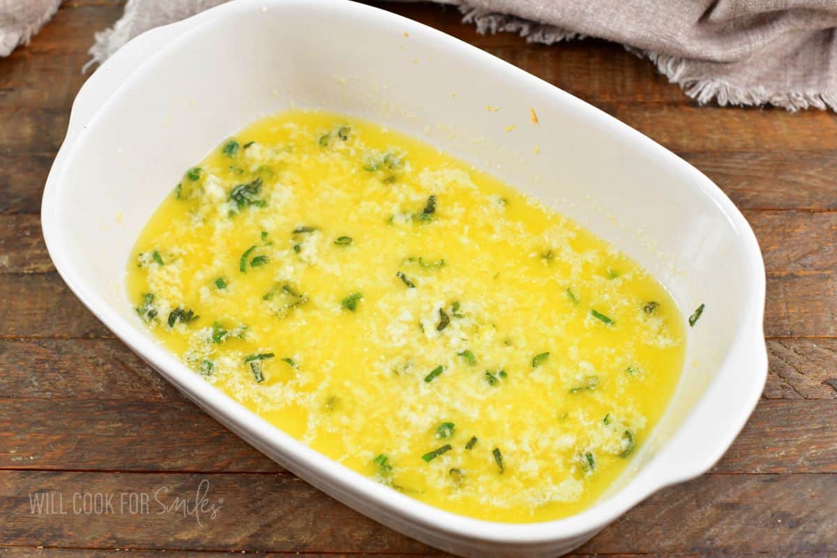 melted butter garlic and herbs in baking dish.