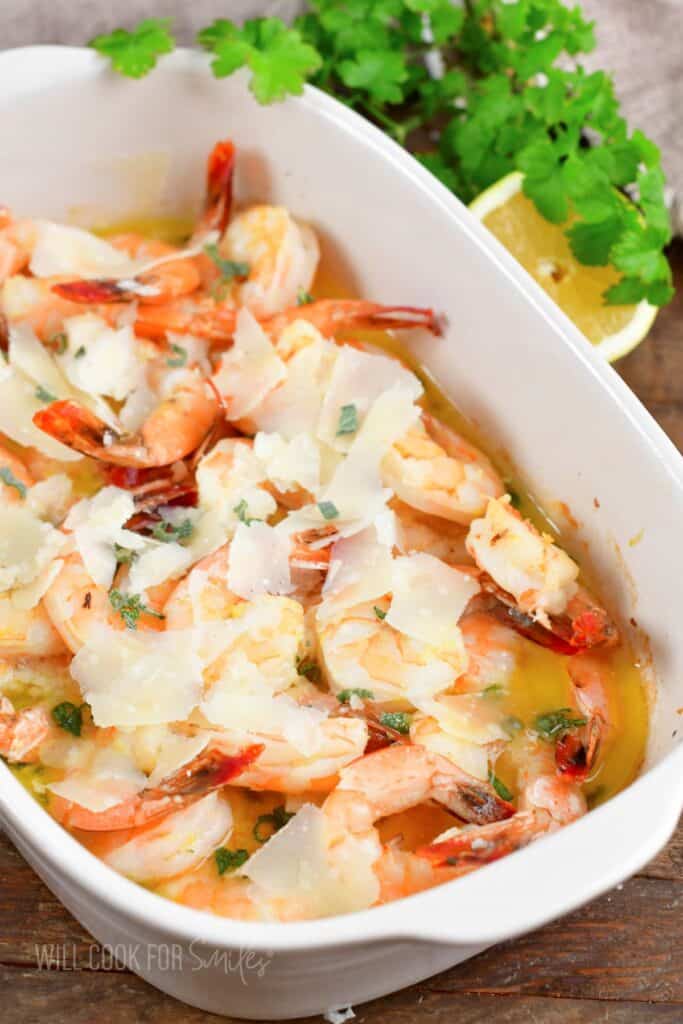 shrimp baked in garlic and butter in white baking dish,