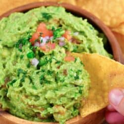 scooping out some guacamole with a chip.