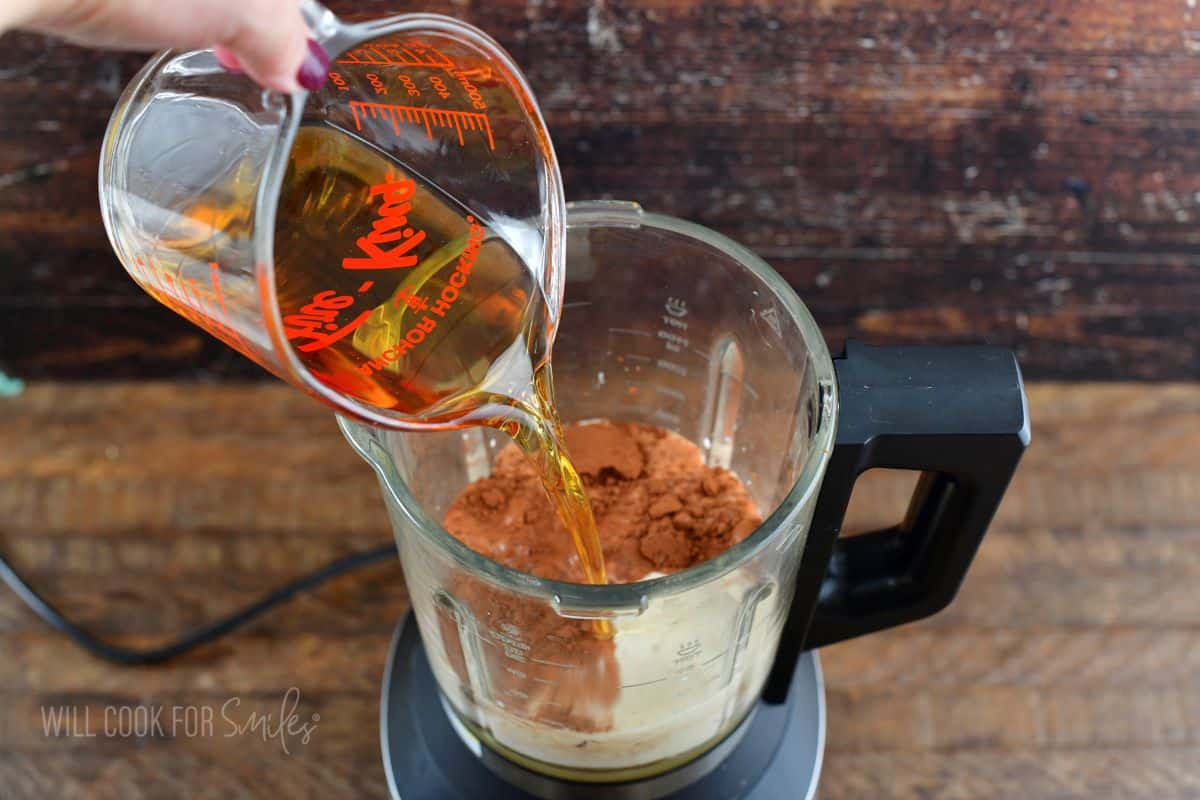 pouring Irish whiskey into the blender.