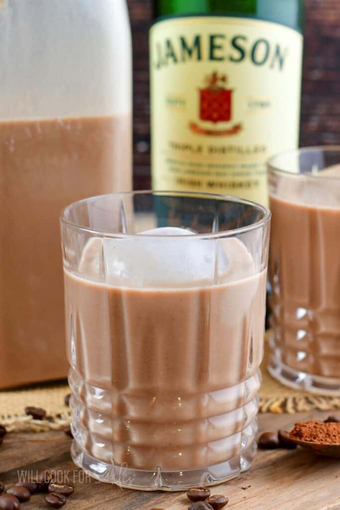 closeup on one rocks glass with Irish cream with ice cube.