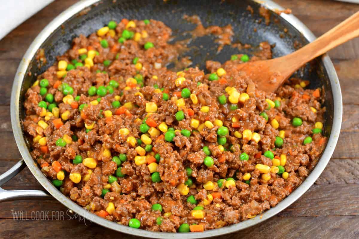 cooked beef with peas. corn, carrots, onion and in sauce.